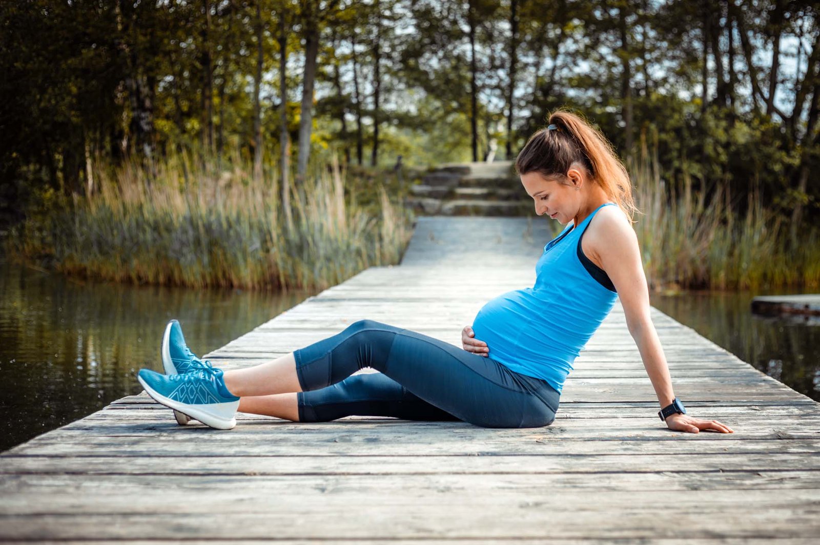 Pregnant woman exercising outdoor and resting